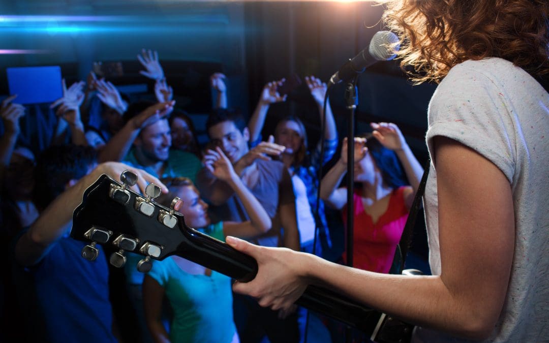 Rock musician guitarist plays a concert in front of an audience for live entertainment